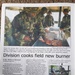 A military newspaper article titled 'Division cooks field new burner' written by Spc. Melissa R. Bernazzani of the 1st Infantry Division PAO. The article covers the First Infantry Division fielding the Modern Burner Unit (MBU) for the first time in United States Army Europe on July 13. Two photographs accompany the article showing soldiers in camouflage uniforms preparing hamburgers on a grill and performing maintenance on the MBU.