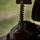 U.S. Marines with 3rd LCT participate in a live-fire basic skills package A close-up photograph showing a person holding a firearm, likely a rifle or carbine, with a loaded magazine visible. The image is taken from a low angle with a shallow depth of field, with a blurred green outdoor background. The person appears to be wearing tactical or military-style clothing.