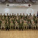 A formal group photograph taken at the YS-91 (Yama Sakura 91) Closing Ceremony, featuring multinational military personnel from the United States, Japan, and Australia. The participants are arranged in four rows in a ceremonial hall, with a banner reading 'YS-91 訓練終了式 / YS-91 Closing Ceremony' displayed prominently behind them. The event appears to be a joint military exercise conclusion ceremony.