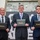 Three men in business suits are posing for a formal photograph while holding black portfolio folders branded with 'Leadership Pittsburgh Inc.' in gold lettering. The setting appears to be an indoor venue with a decorative backdrop. This appears to be a graduation or recognition ceremony for the Leadership Pittsburgh Inc. program.