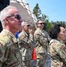 A group of U.S. military personnel in OCP (Operational Camouflage Pattern) uniforms are standing outdoors at what appears to be a field exercise or military event. The individuals are observing something off-camera, with a military tent and speaker system visible in the background. A patch on the foreground soldier's arm reads 'Northern Strike,' indicating participation in a Michigan National Guard joint training exercise.