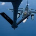 An aerial refueling operation is taking place between a tanker aircraft and a Japan Air Self-Defense Force (JASDF) F-2 fighter jet. The image is taken from the boom operator's position aboard the tanker, looking down at the fighter approaching the refueling boom. The F-2 displays Japanese military markings including the Hinomaru (rising sun) roundel and a two-tone blue/gray camouflage scheme.