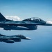 Two Japan Air Self-Defense Force (JASDF) F-2 fighter jets flying in formation over open water or clouds. The lead aircraft bears the tail number '133' and displays the Japanese Hinomaru (red circle) roundel on its fuselage. Both aircraft are painted in a dark blue-gray camouflage scheme typical of JASDF F-2s.