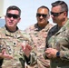 Three U.S. Air Force personnel in OCP (Operational Camouflage Pattern) uniforms are engaged in conversation outdoors in what appears to be a bright, sunny environment. The individual on the left, identified by his name tape as 'Valentine,' holds the rank of Lieutenant Colonel (oak leaf cluster visible) and appears to be briefing or explaining something. The person on the right wears a 'Ranger' tab and U.S. Air Force insignia, while a third individual stands in the background.