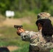 A U.S. Army soldier identified by name tape as 'RICHEY' is firing a pistol at a military shooting range. The soldier is wearing Operational Camouflage Pattern (OCP) uniform and patrol cap, and is using a two-handed grip stance. A spent casing is visible in the air to the right of the weapon, indicating the pistol has just been fired.