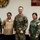 Five military personnel pose for a group photo in front of a 'Specialized School' sign and a Philippine Marine Corps emblem. The group includes members from both the Philippine Marine Corps/Navy and the U.S. Navy/Marine Corps, suggesting a joint military engagement or training event. The setting appears to be inside a Philippine military facility.