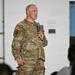 A U.S. Army officer identified by name tape as 'BLANCHARD' is speaking into a microphone at what appears to be a military briefing or town hall event. He is wearing the Operational Camouflage Pattern (OCP) uniform with a U.S. flag patch, 3rd Infantry Division patch, and a general officer star visible on his chest. An audience is partially visible in the foreground as silhouettes.