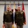 Col. Finch Concludes Distinguished Career, Leaves Lasting Legacy as Command State Chaplain Two U.S. Army officers in dress green uniforms stand at attention before a backdrop of multiple flags including the American flag and Army unit flags. The officer on the right is wearing a medal on his chest, suggesting this is a formal military ceremony such as an award presentation or change of command. Both individuals display rank insignia and service ribbons consistent with senior officer grades.