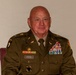 A male U.S. Army soldier in dress green uniform is seated against a plain light-colored wall. His name tag reads 'DREHER' and he displays an extensive array of medals, ribbons, badges, and insignia indicating a long and decorated military career. He appears to be a senior non-commissioned officer or warrant officer based on visible rank and qualification badges.