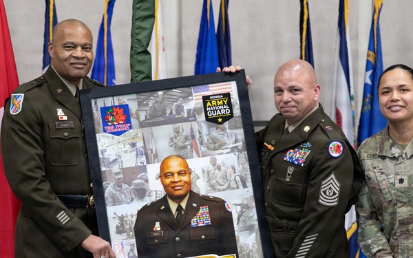 A military ceremony honoring U.S. Army Brigadier General Theodore R. Scott III, with three service members posing with a commemorative framed photo collage. The framed piece displays the dates '01 APR 1986 - 31 AUG 2026' and the motto 'Support the Fight,' along with the Georgia Army National Guard insignia. The ceremony appears to be a retirement or farewell event held in a formal military setting.