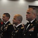 A group of U.S. Army personnel in dress uniforms (Army Service Uniform/Mess Dress) are standing in a formal indoor setting, likely at a military ball or formal ceremony. The soldiers display numerous medals, ribbons, and insignia on their uniforms. They appear to be standing at attention or in a formal posture facing a common direction.