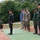 U.S. Marines and Thailand Mine Action Center participate in Deployed for Training Bilateral EOD Exercise A group of military personnel are standing at attention on a green mat over red soil in an outdoor setting. The group includes individuals wearing Thai military camouflage uniforms with 'TMAC' caps bearing Thai flag patches, US Marine Corps MARPAT uniforms, and one civilian in casual clothing. The scene appears to be a formal military ceremony or inspection, likely a joint multinational exercise.
