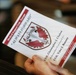 A hand holds a military ceremony program for the Medical Support Unit - Europe, featuring the 'Valkyrie' unit insignia. The program documents a change of command ceremony where COL Christopher J. Chabot relinquishes command to COL Tyler J. Ranney. The event took place on 13 September 2026 at 1000 Hours, BLDC 17, Sembach, Germany.