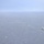Ships sail in formation during Phoenix Express 2026 An aerial photograph shows a naval formation of approximately 7-8 warships sailing in a single-file line column across open ocean. The vessels appear to be gray-painted military ships of varying sizes, photographed from an elevated vantage point, likely from an aircraft. Hazy atmospheric conditions reduce visibility, particularly for the more distant vessels in the formation.