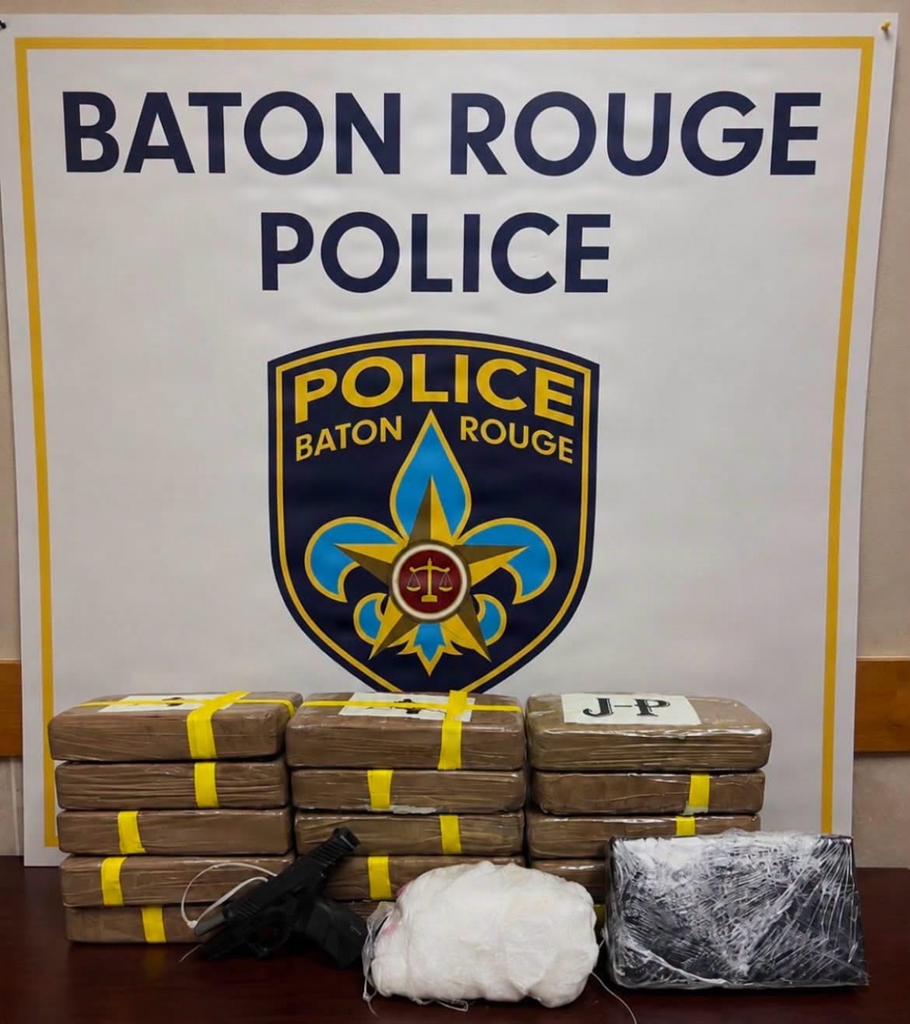 This is an official law enforcement evidence display photograph taken by the Baton Rouge Police Department. The image shows seized contraband items arranged on a table in front of a Baton Rouge Police Department backdrop. This appears to be a standard press/public information photo documenting a drug seizure.
