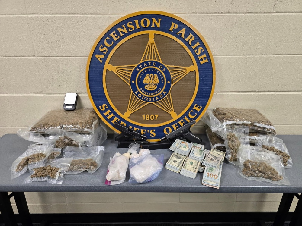 This is an official law enforcement evidence display photograph from the Ascension Parish Sheriff's Office in Louisiana. The image shows seized contraband, currency, and a firearm arranged on a table in front of the agency's official seal. This type of photograph is typically used for press releases or official documentation of drug-related arrests.