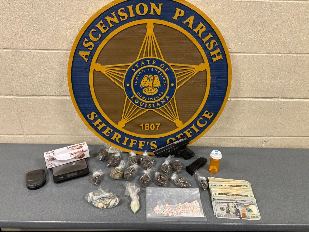 This is an evidence display photograph taken by the Ascension Parish Sheriff's Office in Louisiana. The image shows seized contraband and related items laid out on a table in front of the official agency seal. This appears to be a standard law enforcement evidence documentation photograph.