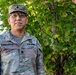 A U.S. Army officer in OCP (Operational Camouflage Pattern) uniform is posing outdoors in front of a leafy tree. The soldier's name tape reads 'CAMPORESE' and rank insignia on the cap and chest indicate the rank of Lieutenant Colonel (oak leaf). The image appears to be an official or semi-official portrait photograph taken in a garrison environment.