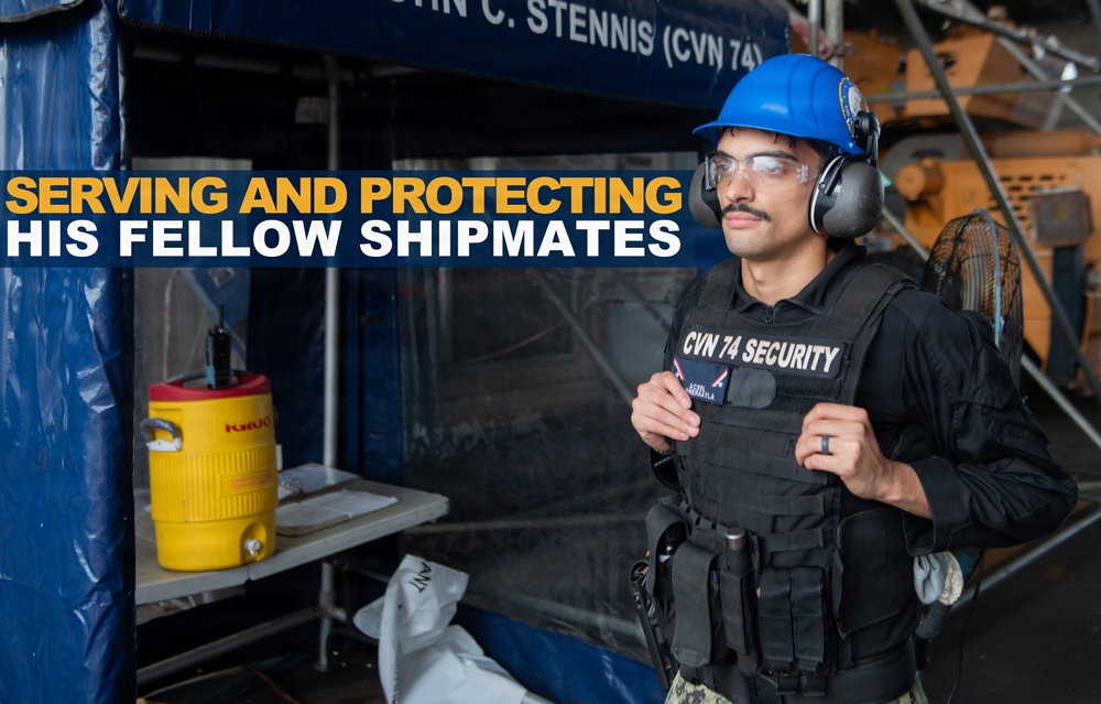 A security personnel member assigned to CVN 74 (USS John C. Stennis) is shown wearing a tactical vest labeled 'CVN 74 SECURITY', a blue hard hat, safety glasses, and hearing protection. The image appears to be an official U.S. Navy promotional or informational graphic with the overlay text 'SERVING AND PROTECTING HIS FELLOW SHIPMATES'. The setting appears to be aboard the aircraft carrier during a maintenance or industrial work period.