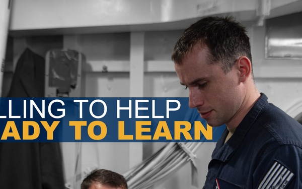 A promotional military image showing two personnel in dark blue uniforms reviewing documents together aboard what appears to be a naval vessel. The standing individual is identified by a name tag as 'Austin Dockins' and wears a US flag patch on his sleeve. The image includes overlaid text reading 'WILLING TO HELP / READY TO LEARN,' suggesting a recruitment or training context.