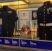 A museum display case honoring SGTMAJ Michael S. Curtin, featuring his NYPD Emergency Service Unit uniform and U.S. Marine Corps dress uniform. The exhibit includes a New York City Police Department Medal of Honor certificate, a USMC helmet, medals, ribbons, and informational plaques. The display commemorates his dual service as both a New York City police officer and a U.S. Marine.