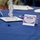 A decorated banquet table set up for a 'Retiree Appreciation Day' event, featuring patriotic red, white, and blue decorations. The table displays a tent card thanking retirees for their service, along with decorative gemstones and a silver centerpiece. The setting suggests a formal military or government retiree recognition ceremony.