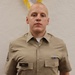 A young male in a khaki military-style uniform stands at attention in front of a white textured wall. He wears a name tag reading 'BALL' on his left chest pocket and a ribbon medal on his right chest. The photo appears to be a formal military or JROTC portrait.