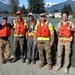 Members of the USACE and City and Borough of Juneau team pose for a photo in front of the flood barrier project while performing spot checks during the glacial lake outburst flood