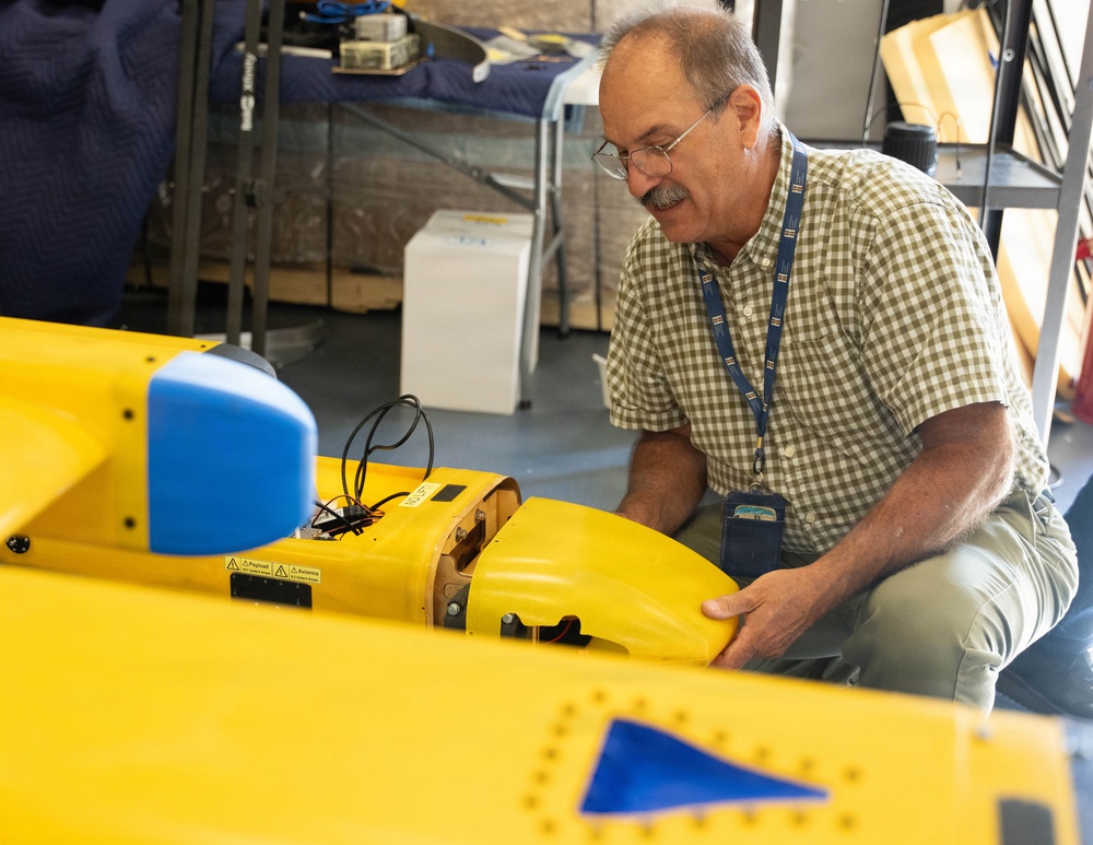 Technician Performs Maintenance on Yellow Unmanned Surface Vessel