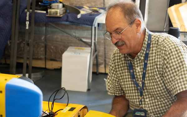 Technician Performs Maintenance on Yellow Unmanned Surface Vessel