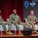 Three U.S. Army soldiers in OCP (Operational Camouflage Pattern) uniforms are seated in white chairs on a stage during a panel discussion or briefing. The backdrop displays the '1st SFC' (1st Special Forces Command) logo with two stars and the motto 'De Oppresso Liber.' Name tapes visible on the uniforms include 'Owens' (center) and 'Ferguson' (right).
