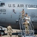U.S. Air Force personnel from the 911th Airlift Wing are working on or near a military transport aircraft (tail number 0601) on a flight line. They appear to be installing or positioning a sign reading 'Roberto Clemente' on the aircraft's boarding stairs. This appears to be a naming ceremony or commemorative event honoring the legendary baseball player Roberto Clemente.