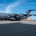 A U.S. Air Force C-17 Globemaster III military transport aircraft is parked on a tarmac at what appears to be an Air Force Reserve base. The aircraft bears the tail number 0601, is assigned to the 911th Airlift Wing, and has a nose art inscription reading 'Roberto Clemente'. A water tower labeled 'Air Force Reserve' is visible in the background.
