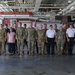 A group photo taken inside the Keesler Fire Rescue station, showing approximately 20-25 individuals including military personnel in camouflage uniforms, civilian fire rescue staff in white shirts, and other personnel. The group is posed in front of a red fire apparatus with the 'Keesler Fire Rescue' sign visible overhead. This appears to be an official visit or joint training event at Keesler Air Force Base in Mississippi.