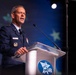 A senior U.S. Air Force officer in dress uniform is delivering a speech at a podium bearing the AFA (Air Force Association) logo. The speaker appears to hold a high-ranking position based on the visible insignia and medals on his uniform. The setting is a formal conference or symposium event.