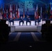 A panel discussion is taking place on stage at the AFA (Air Force Association) Air Space Cyber Conference, described as 'A Professional Development Event.' Four military officers in dress uniforms are seated on stage while a civilian moderator speaks at a podium on the left. The audience, visible in silhouette in the foreground, is seated in a darkened auditorium.