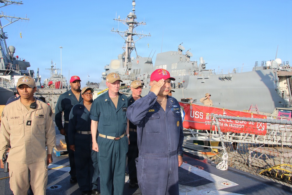 U.S. Navy sailors render honors aboard USS Russell (DDG-59) during pier-side ceremony