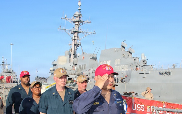 U.S. Navy sailors render honors aboard USS Russell (DDG-59) during pier-side ceremony