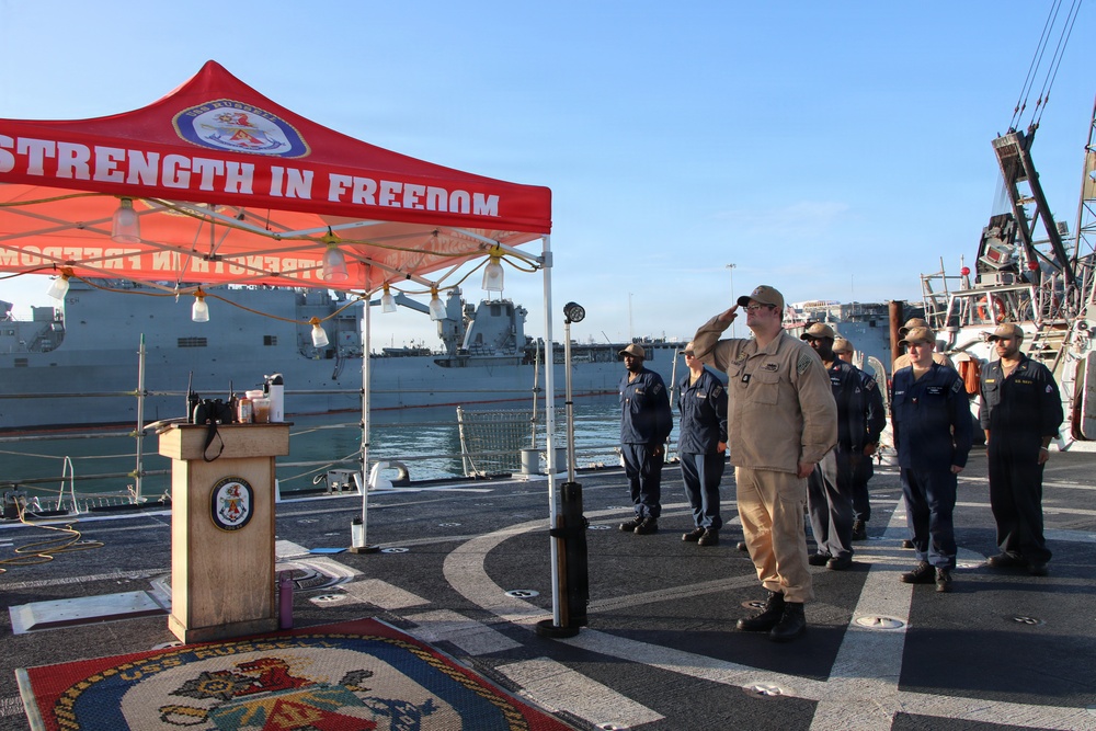 U.S. Navy Sailor Renders Salute During Ceremony Aboard Warship at Port