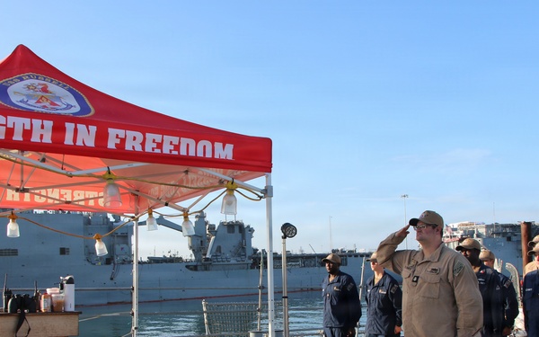 U.S. Navy Sailor Renders Salute During Ceremony Aboard Warship at Port