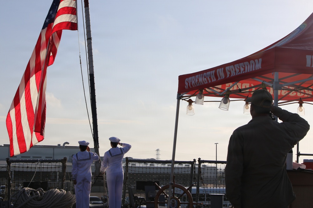 U.S. Navy Chief Selectees and service member render honors during colors ceremony aboard naval vessel