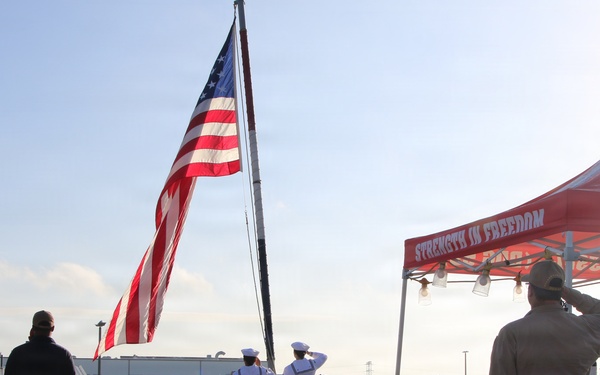Sailors render honors during colors ceremony aboard USS RUSSELL
