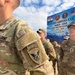 US Army soldiers in MultiCam/OCP camouflage uniforms are gathered at the Yudh Abhyas XXII India-USA Joint Military Exercise. The foreground soldier displays an '11th Airborne Division' patch with 'Arctic' and 'Airborne' tabs on the left sleeve. A banner in the background identifies the exercise as taking place 19-28 September 2023 at AULI-MFFR.