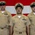 USS Tripoli Chief Pinning Three U.S. Navy enlisted personnel in Service Khaki uniforms are standing in formation in front of a large American flag backdrop. All three wear Chief Petty Officer or Senior Chief Petty Officer covers and display multiple service ribbons, warfare qualification badges, and rank insignia. The setting appears to be a formal military ceremony or official photo.