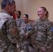 A U.S. Army senior officer is shaking hands with soldiers during what appears to be a formal recognition or greeting ceremony. The soldiers are wearing OCP (Operational Camouflage Pattern) uniforms with KFOR (Kosovo Force) NATO patches, indicating deployment to Kosovo. Three female soldiers are visible, with one named 'ZSIDO' prominently in the foreground.