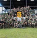 A large group of U.S. Marines poses for an official unit photograph outdoors. They are members of MALS-31 'Stingers,' as indicated by the unit patch/banner held in the center of the group. The photo appears to be taken at a military installation, likely Marine Corps Air Station Beaufort or a similar facility.
