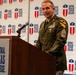 A U.S. Army senior non-commissioned officer in dress green uniform is speaking at a podium during an event at Central Texas College. The soldier displays numerous service ribbons, medals, and unit patches including the 1st Cavalry Division patch. The setting appears to be a formal institutional event or ceremony.