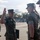 Chief Warrant Officer 2 Joshua J. Krantz’s Promotion Ceremony A military ceremony appears to be taking place outdoors on a paved area, likely a promotion or re-enlistment ceremony. A Marine in the center is raising his right hand while holding a folder, suggesting he is taking an oath, while another Marine renders a salute. Additional uniformed personnel are visible in the background.