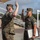 Chief Warrant Officer 2 Joshua J. Krantz’s Promotion Ceremony Two U.S. Marines in MARPAT camouflage uniforms are engaged in what appears to be a formal oath or re-enlistment ceremony outdoors on a military installation. The Marine on the right is holding a framed certificate or document while both individuals have their right hands raised. The setting appears to be a parade deck or outdoor ceremonial area.