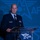 Next-Generation Battle Management - AFA Panel A uniformed U.S. Air Force or Space Force officer is speaking at a podium during an Air & Space Forces Association (AFA) event. The officer is wearing a dark blue service dress uniform with multiple ribbons and decorations. The backdrop prominently displays the AFA logo repeated across a blue-toned background.